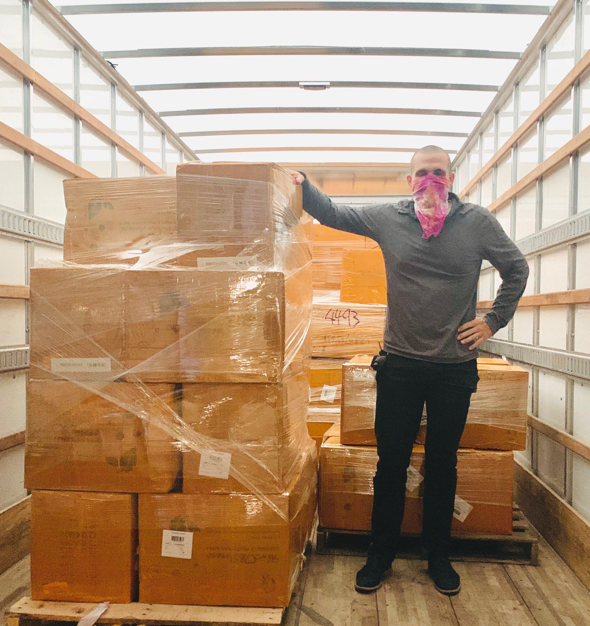 man in atruck with packages of personal protection equipment to donate