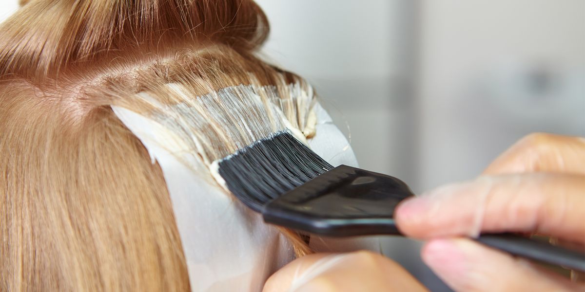 hair dye being applied to a female's hair with a brush