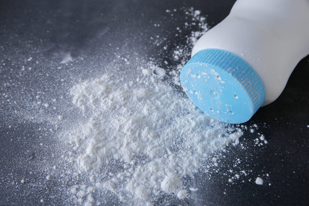 talc baby powder spread on dark background