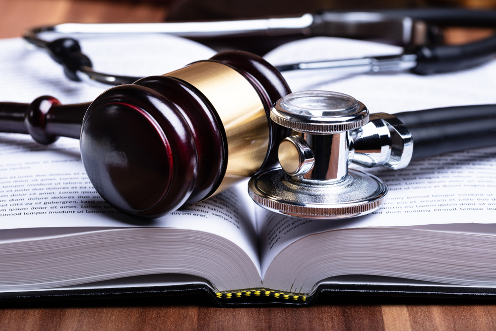 closeup of a gavel and stethoscope laying on an open book. medical malpractice concept