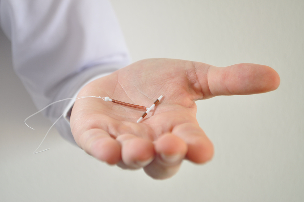 Holding an Paragard IUD birth control copper coil device in hand