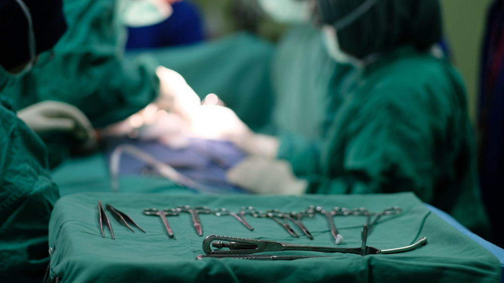 surgery of Inguinal Hernia Repair or hernioplasty using hernia mesh implant with instruments in the forefront