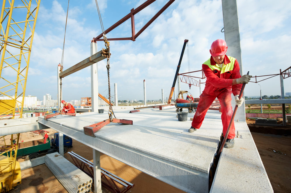 construction workers setting a concrete slab at jobsite