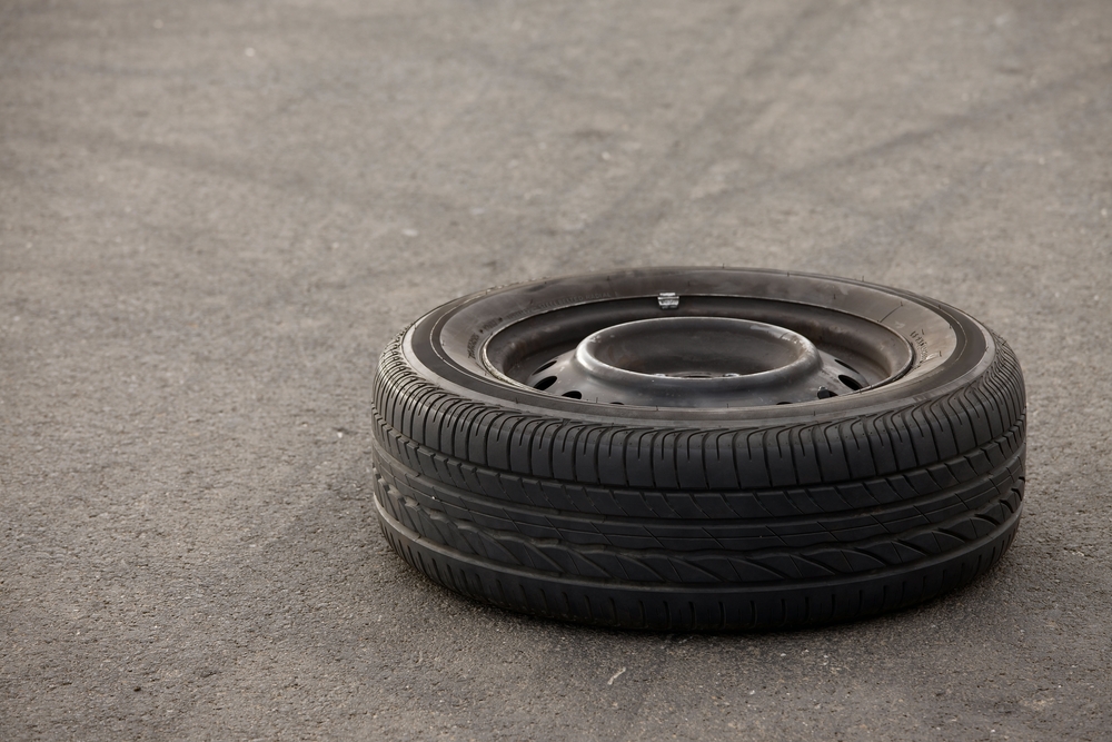 a car tire laying isolated on a roadway