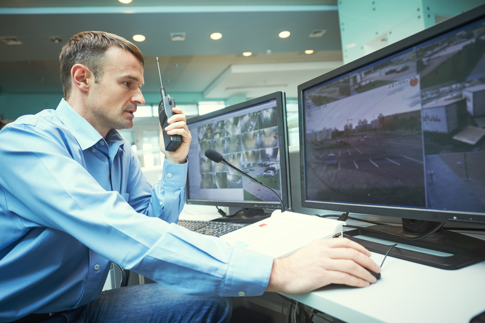 a male security guard monitoring the video surveillance system at a business