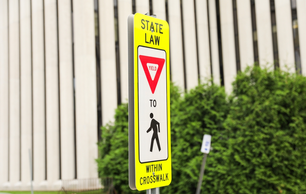 a yield to pedestrians sign on an urban street