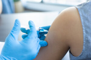 closeup of a young woman getting a depo-provera birth control injection from a doctor with a syringe.