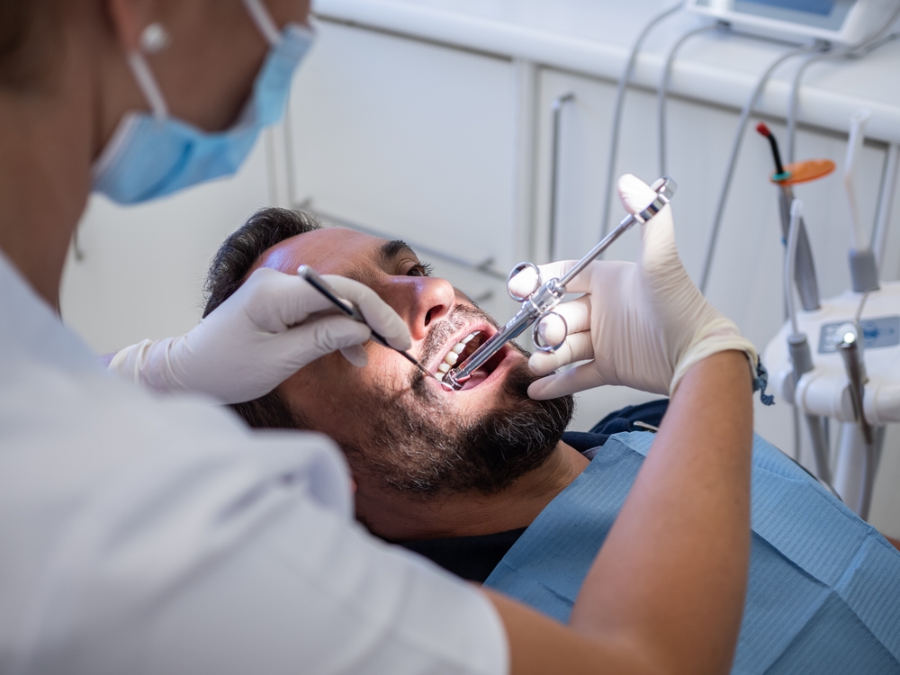 male patient at dentist office getting anesthesia injection